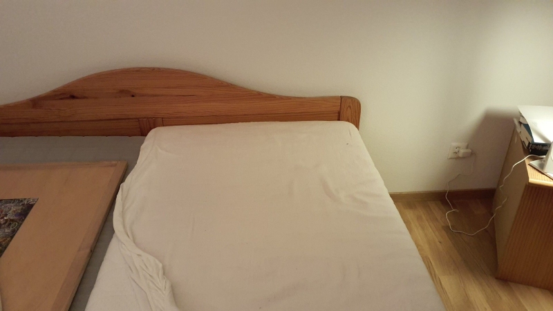 Ein schlichtes Schlafzimmer in Kilchberg zeigt ein freigelegtes Bett, was bei Verdacht auf Bettwanzen den Einsatz eines Kammerjaeger nahelegt.