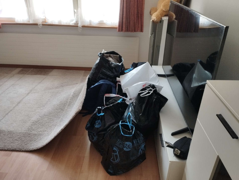 In Tenniken sind Bettwanzen in einem Raum sichtbar, der durch verschiedene Gegenstände und Säcke teilweise belegt ist. Kammerjäger könnten hier zur effektiven Bekämpfung erforderlich sein.