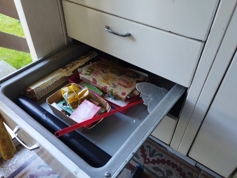 In einer herausgezogenen Schublade in Grellingen liegen angenagte Verpackungen und verstreute Reste, was auf Maeusebefall hindeutet und den Einsatz eines Kammerjaegers notwendig macht.