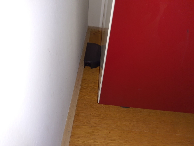Hinter einem Schrank in Langenbruck steht eine kleine Koederbox an der Wand, was auf Aktivitaet von Maeusen hindeutet und den Einsatz eines Kammerjaegers erforderlich macht.