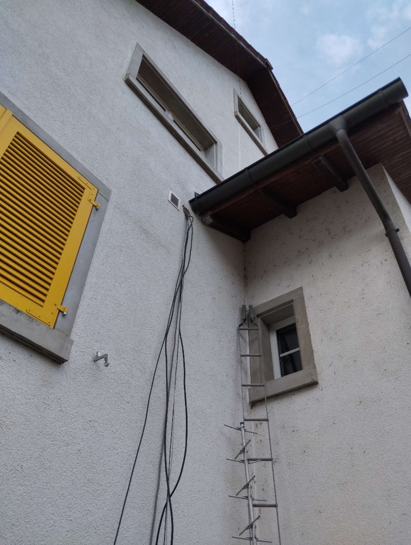 Am Haus in Dittingen haengt ein kleines Wespennest nahe der Dachrinne, wodurch ein Kammerjaeger im Ort sinnvoll werden kann.