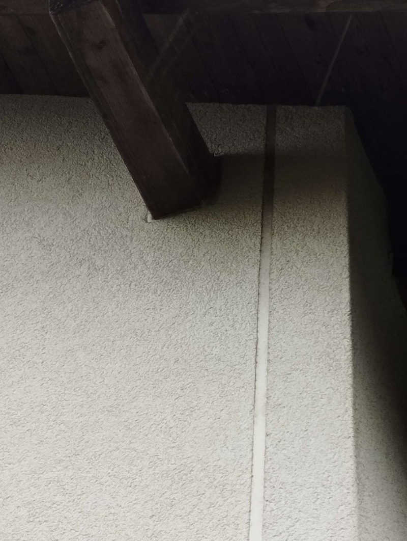 Unter dem dunklen Dachbalken an einer Hauskante in Muttenz deutet eine geschuetzte Stelle auf ein moegliches Wespennest hin, das den Kammerjaeger erforderlich macht.