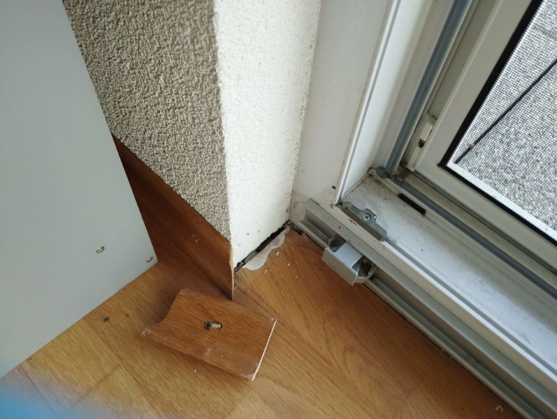 Nahe der Fensterecke fallen in Anwil feine Spuren und kleine Ansammlungen auf, die auf Ameisen hindeuten und den Einsatz eines Kammerjaegers erfordern koennten.