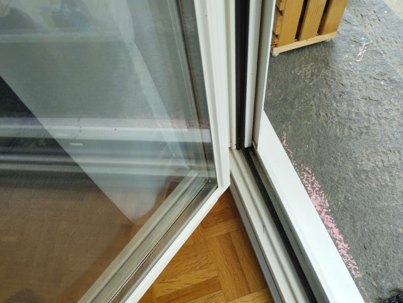 Am unteren Rand der offenen Balkontuer in Blauen weist die feine Spur entlang der Fuhrungsschiene auf Ameisenaktivitaet hin, bei der ein Kammerjaeger hilfreich sein kann.